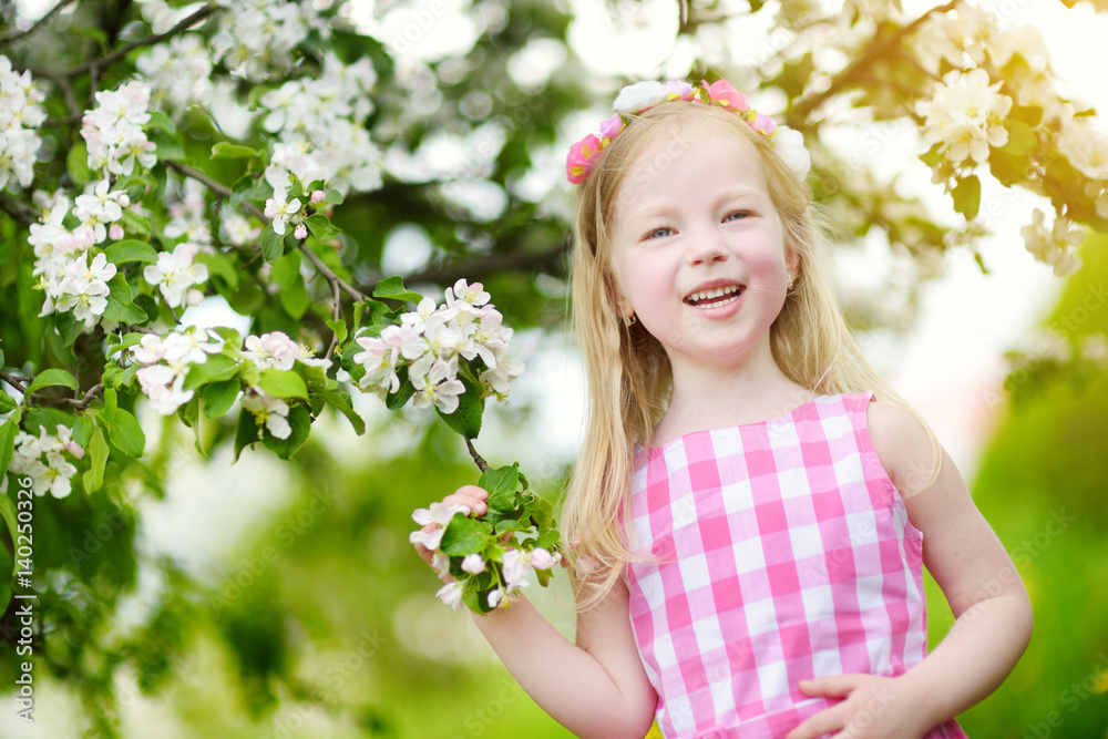 Adorable little girl in blooming apple tree garden on beautiful spring day Adorable little girl in blooming apple tree garden on beautiful spring day