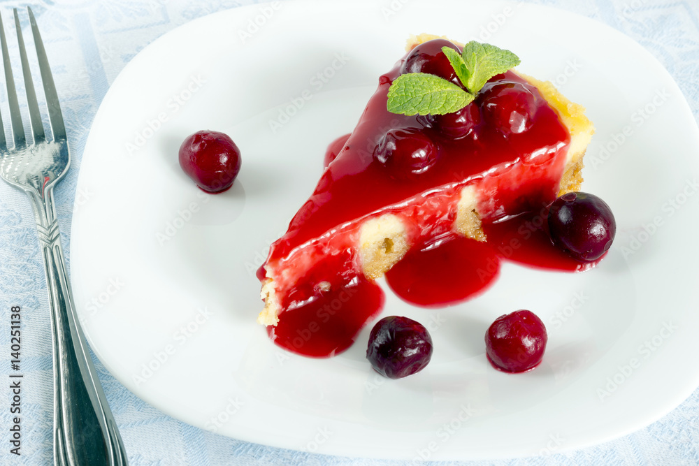 Homemade cherry cheesecake in white plate on light cloth napkin Homemade cherry cheesecake in white plate on light cloth napkin