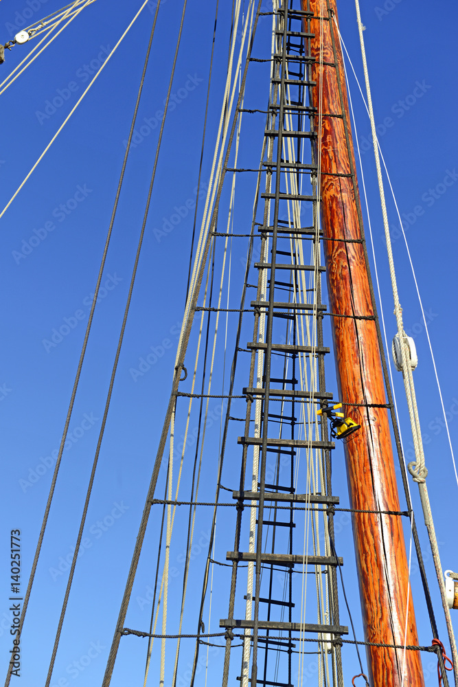 Nautical maritime scene with ropes and mast on a ship on a dock by the water Nautical maritime scene with ropes and mast on a ship on a dock by the water