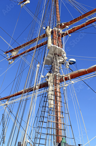 Nautical maritime scene with ropes and mast on a ship on a dock by the water