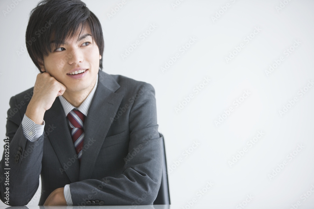 Young businessman with hand on chin Young businessman with hand on chin