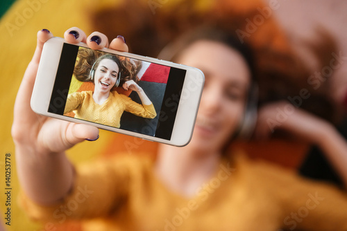 Top view of beautiful young woman in headphones making selfie