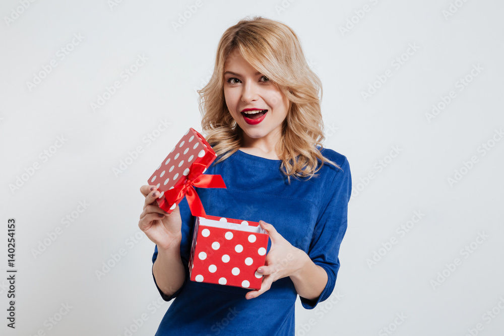 Happy young woman holding gift box over white background. Happy young woman holding gift box over white background.