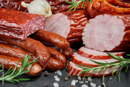 Obraz na plátne Set of cold cuts on a stone board. Mix of sausages