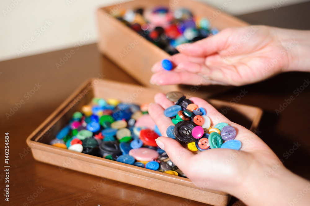 Fototapeta premium colorful sewing buttons in the hands