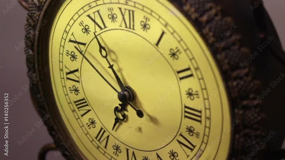 An old antique bronze clock ticks slowly by An old antique bronze clock ticks slowly by