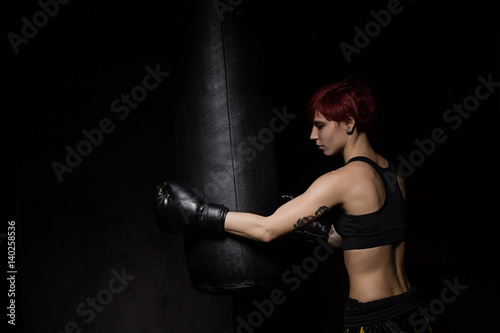 Athlete boxer woman punching a punching bag © Iryna