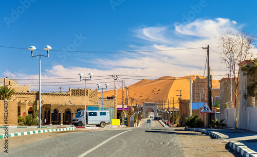 View of a Saharan dune from a street in Merzouga village, Morocco photo