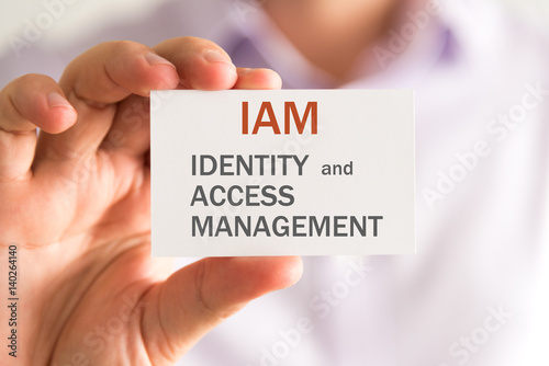Obraz na płótnie Businessman holding a card with IAM IDENTITY AND ACCESS MANAGEMENT message w salonie