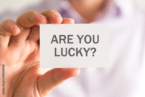 Businessman holding a card with ARE YOU LUCKY ? message