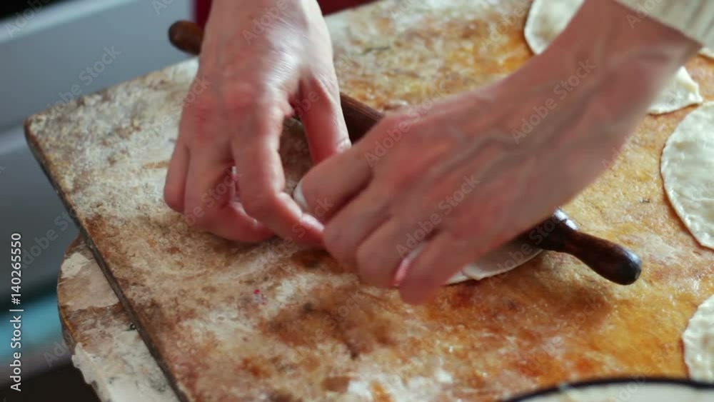 Woman prepares meat pies, working with the dough and filling, close-up Woman prepares meat pies, working with the dough and filling, close-up