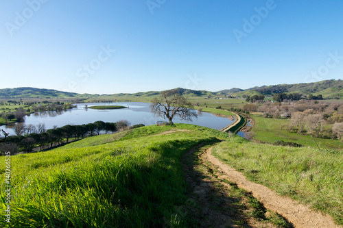Panoramic view of the Lagoon Valley Park in Vacaville, California, USA, featuring the chaparral in the winter with green grass, and the lake