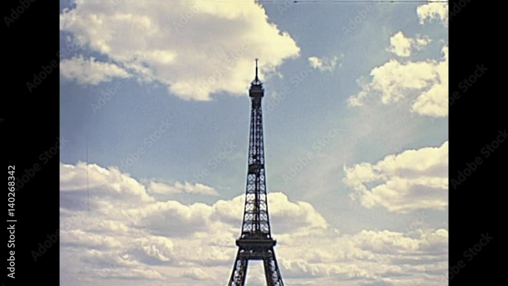 Paris Eiffel Tower panorama from Palais de Chaillot palace. Jardins du Trocadero gardens with tourists looking. Historic restored footage on 1976 in France. Parisians in vintage fashion clothing.