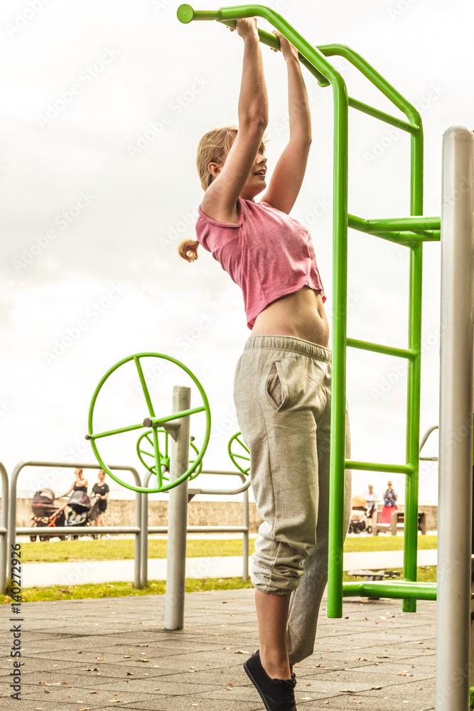 Active woman exercising on ladder outdoor.
