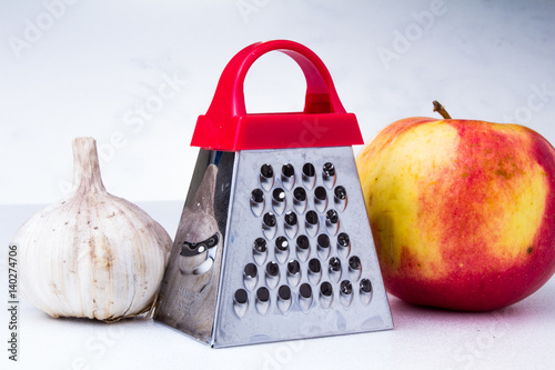 Still life: vegetables and fruits.apple, garlic, onion with small grater photo
