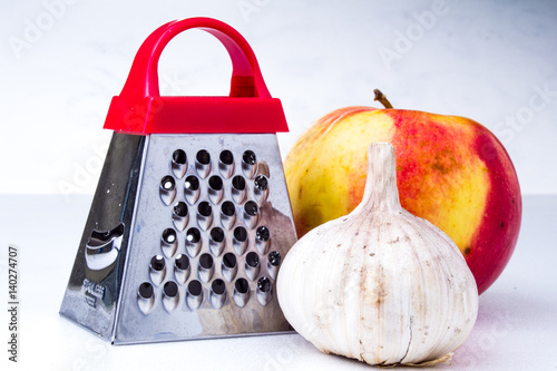 Still life: vegetables and fruits.apple, garlic, onion with small grater photo