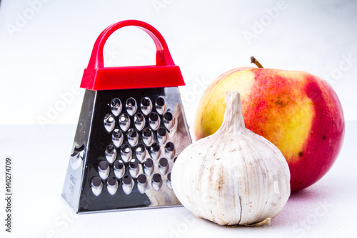 Still life: vegetables and fruits.apple, garlic, onion with small grater photo