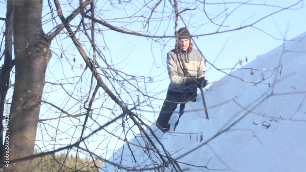 Man removing snow from the roof with a shovel Man removing snow from the roof with a shovel