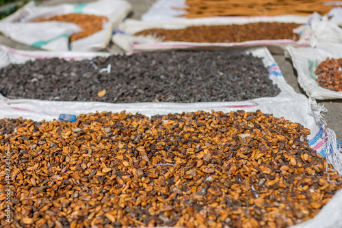 Cocoa beans other spices drying out in the street in the midday sun.