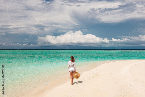 Woman with sun hat on tropical beach