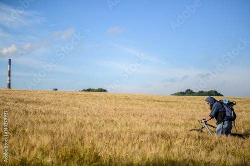 hipster man on a bicycle in the field