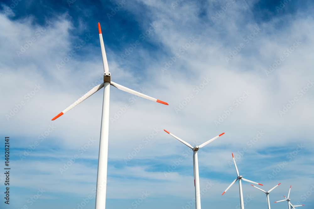Wind turbines  against a blue sky generating electricity