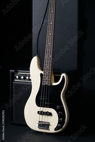 Black and white electric bass guitar,hard case on black background .