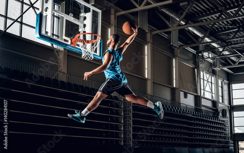  Black basketball player in action in a basketball court. © Fxquadro