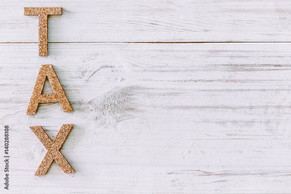 Alphabet TAX on wooden background