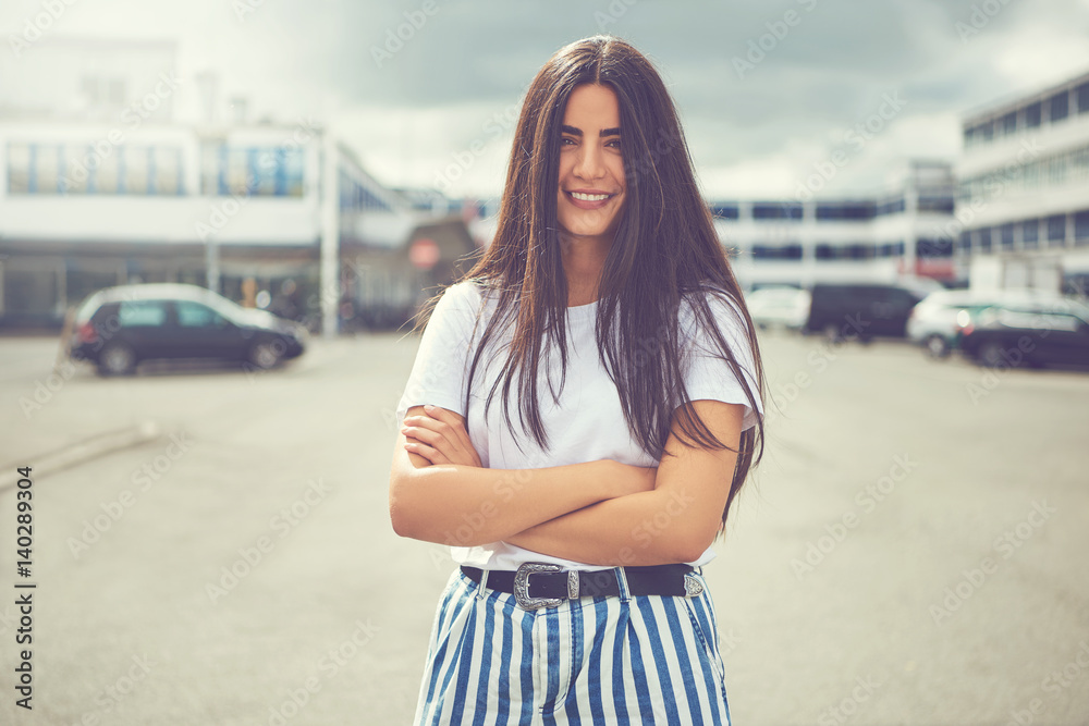Woman with striped pants and folded arms outside Woman with striped pants and folded arms outside