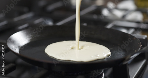 Obraz na plátně preparing blini or crepes batter pouring on hot pan, 4k photo