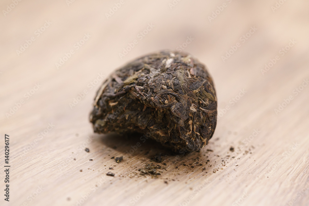 part of raw green puerh tea on wood table, shallow focus part of raw green puerh tea on wood table, shallow focus