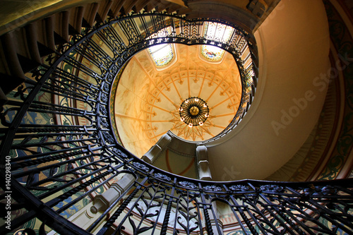 Spiral staircase in the hall with stained-glass window