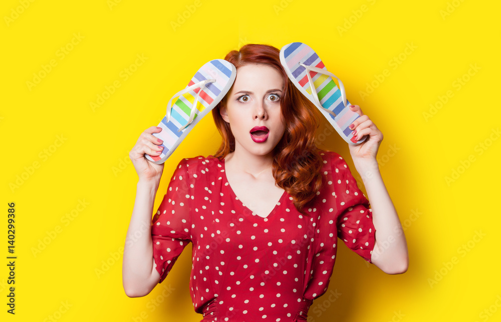 beautiful surprised young woman with colorful sandals on the wonderful yellow background