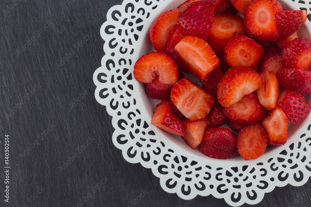 Strawberries on a white plate / Red Freshly cut strawberries on a white artistic plate