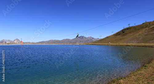 Tyrolienne au-dessus d'un lac de haute montagne des Alpes