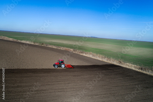 Tractor harrowing soil in spring © Budimir Jevtic