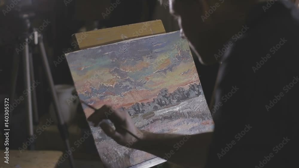 The artist paints a painting in the studio The artist paints a painting in the studio