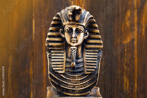 Souvenir sculpture of the Egyptian pharaoh on the wooden background