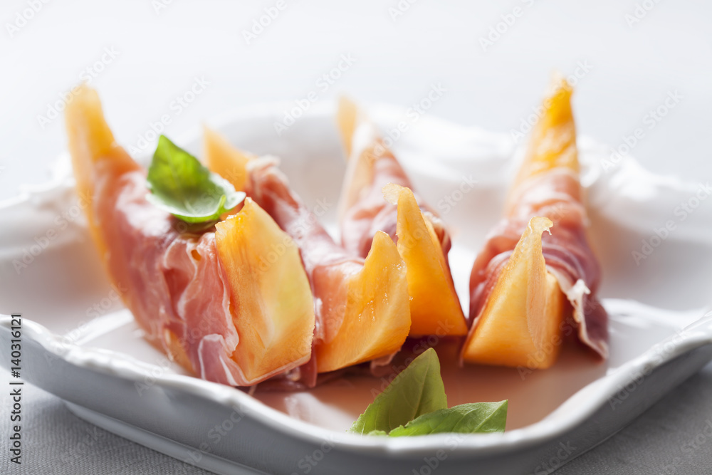 Slices of cantaloupe melon and prosciutto ham, shallow DOF