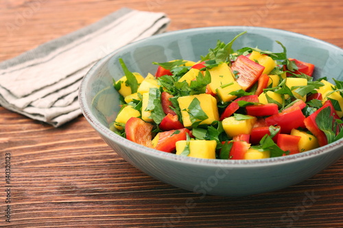 Mango salad with pepper and parsley in a bowl. Healthy low fat detox eating concept.