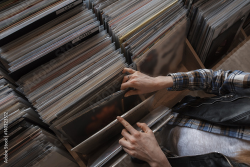 Foto female hands browsing vinyl records in a store