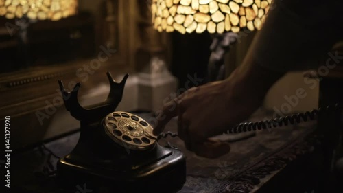 Dialing a number on a Old style Retro Black Antique Rotary telephone. World War II style telephone used for military communications. mafia style movies