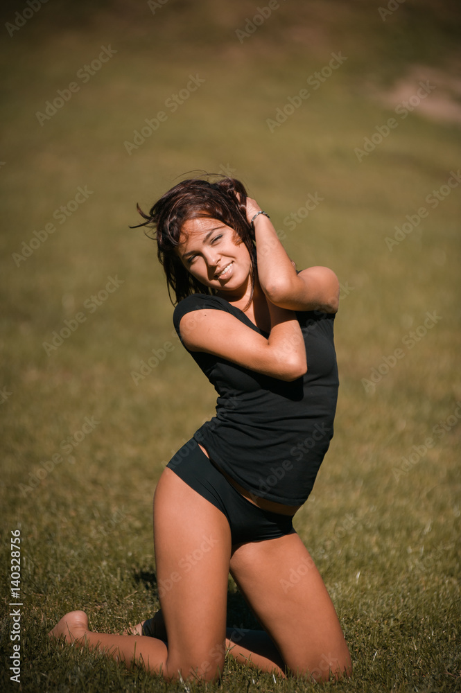 pretty girl performing fitness activities and stretching on the lawn