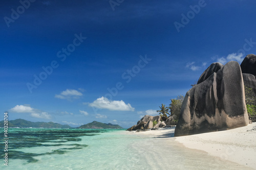 Big granite stones on the white-sand beach next to turquoise water