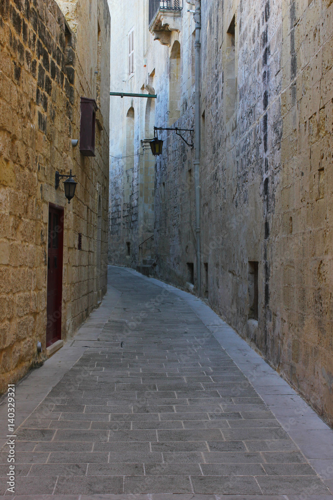 Narrow street with a lantern in old town Mdina, Malta