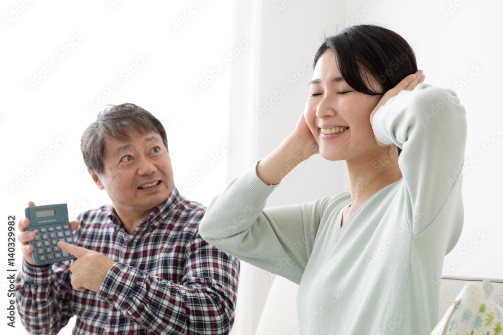 Fototapeta premium 電卓を見せる父親、耳をふさぐ娘、喧嘩、説教