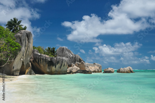 Big granite stones on the white-sand beach next to turquoise water © chalik