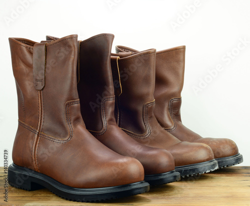 Two pairs of brown color leather safety boot with white backgrou