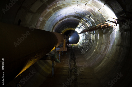 Abandoned tunnel under the railway with pipes of a heating main in Voronezh.